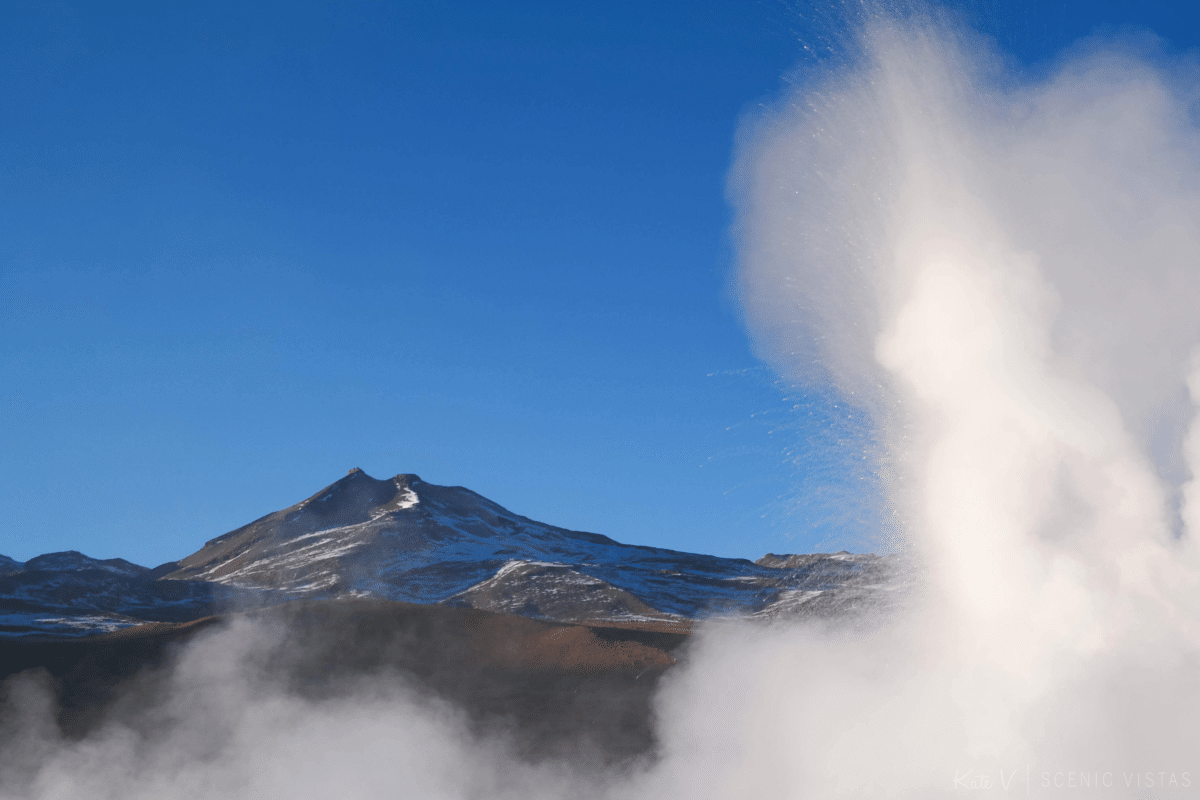 Steam rising from the Tatio Geysers in front of the mountains.